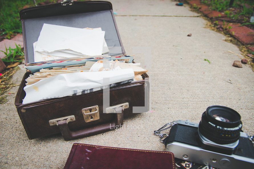 papers in an old suitcase, journal, and camera
