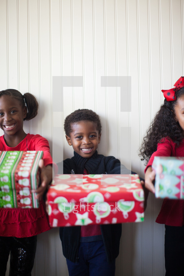 children holding wrapped gifts Christmas 