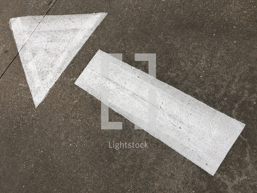 arrow stenciled on pavement, giving direction, diagonal angle pointing up