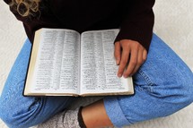 a woman in socks reading a Bible 