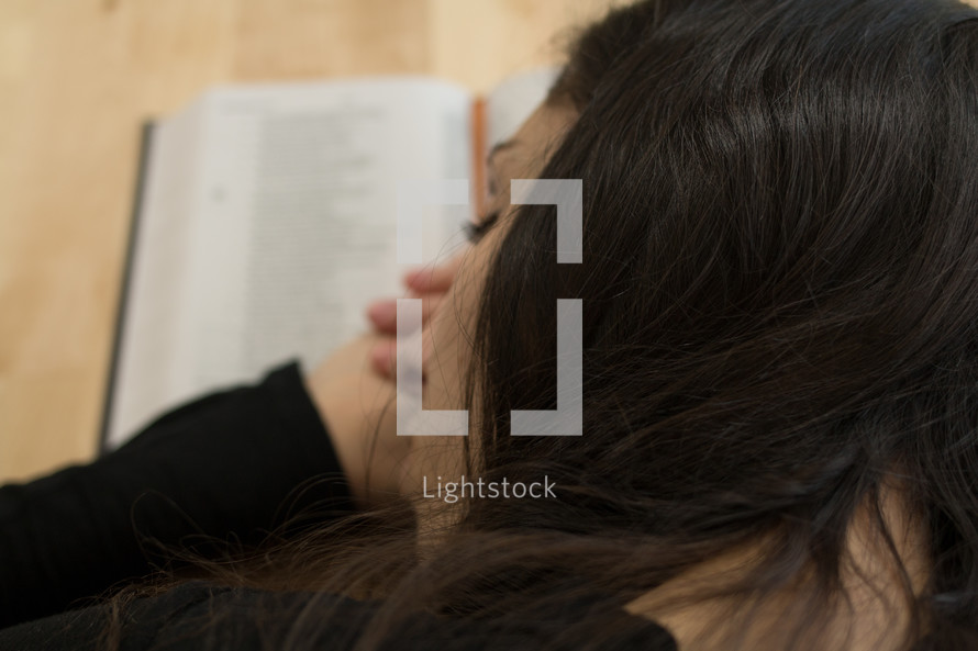 a woman sleeping on an open book 