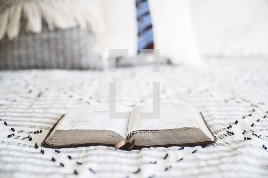 a Bible on a bed 