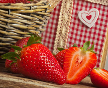 Beautiful strawberries with cookbook on wooden table