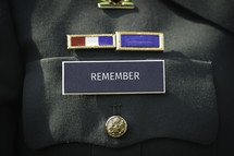 The word "remember" printed on the military name badge of uniform. 