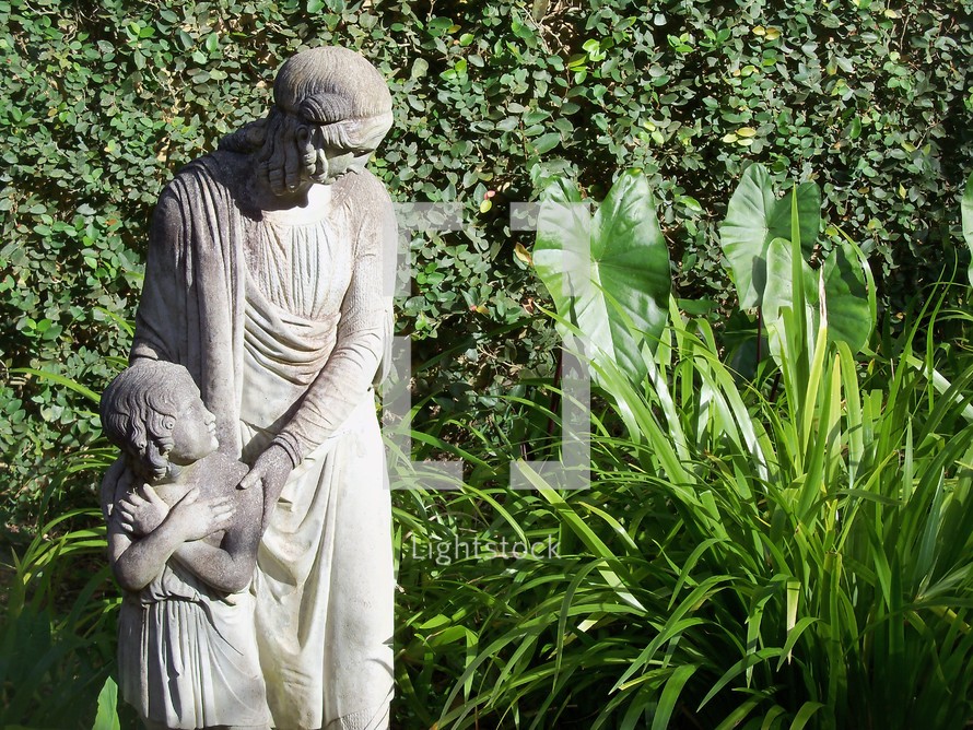 An image of a mother and child statue of a mother protecting her daughter from an unseen danger in the woods and wild. 