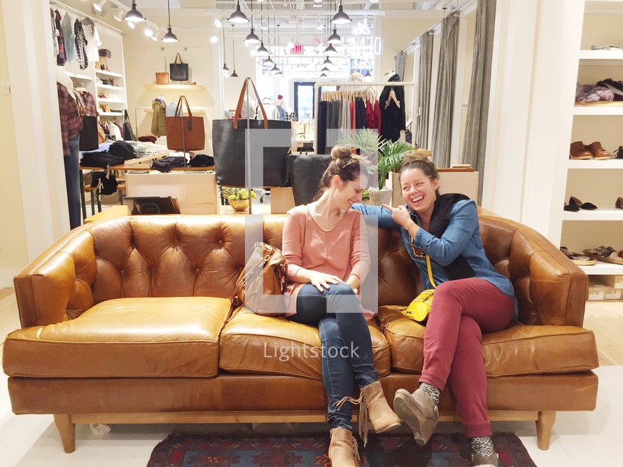 women sitting on a couch in a store boutique 