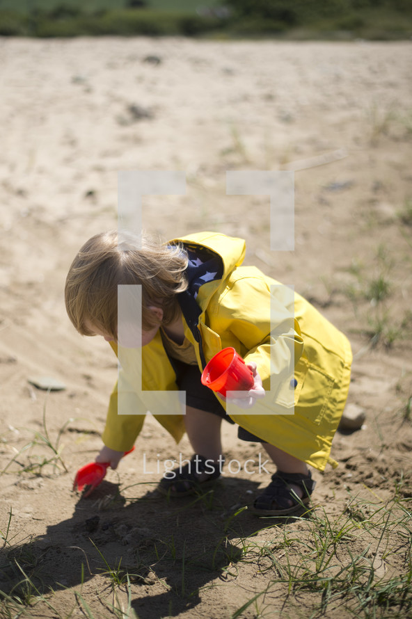 toddler boy digging in sand