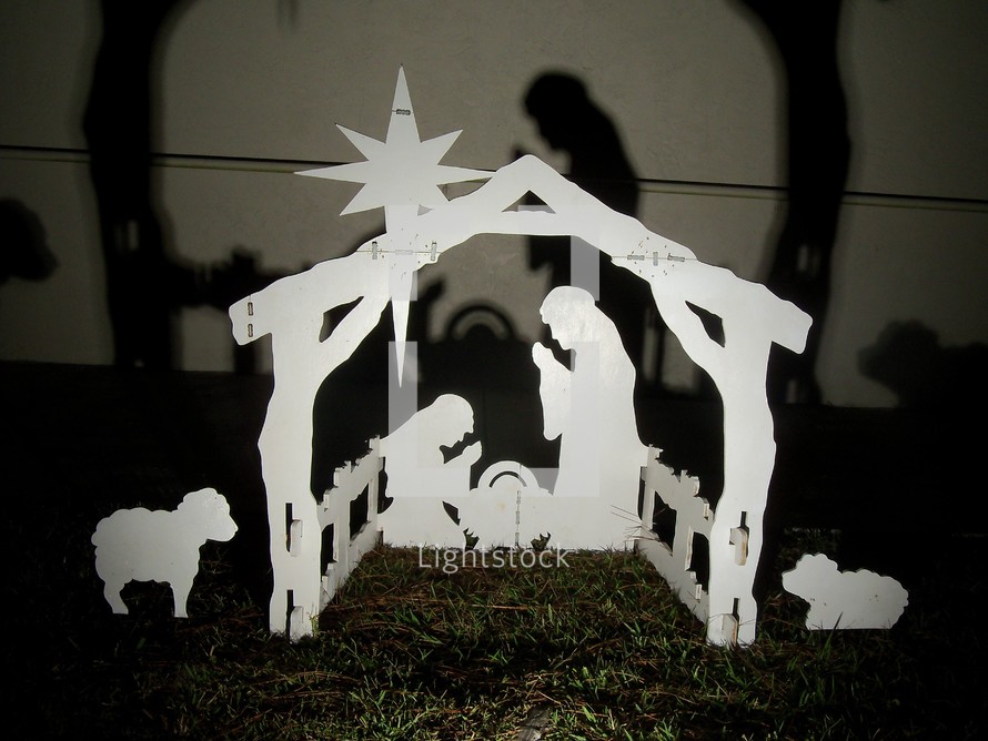 Wooden, outdoor nativity scene casting shadows
