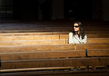 Woman praying in church and looks invisible presence to her right