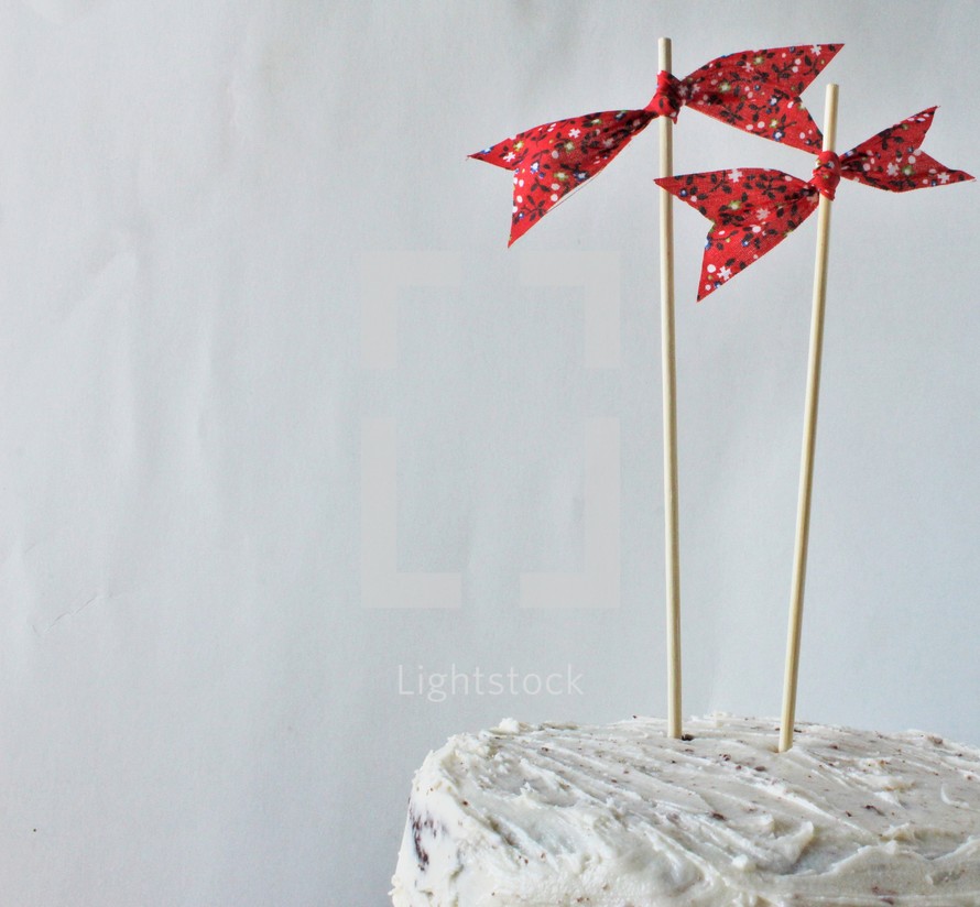 red bows on sticks on a cake 