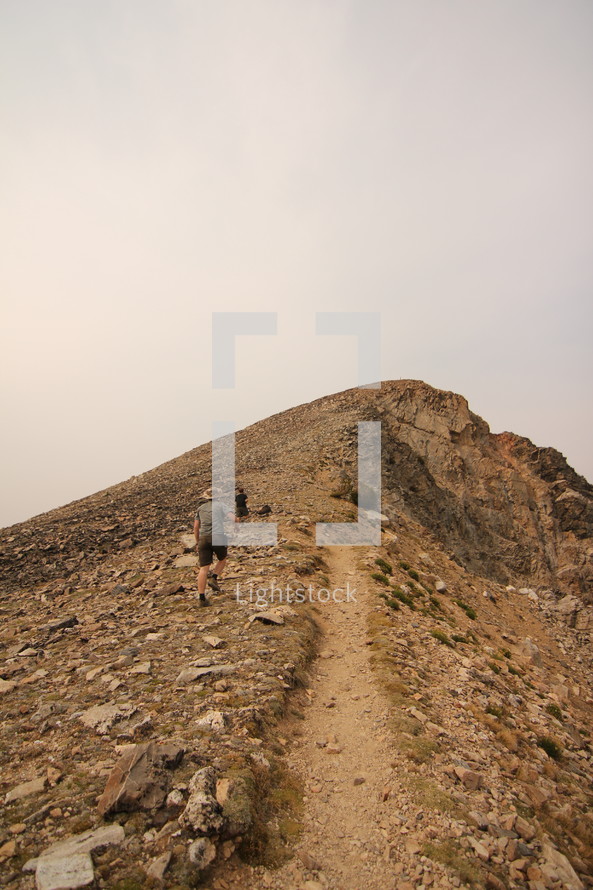 a man walking up a steep rocky slope 