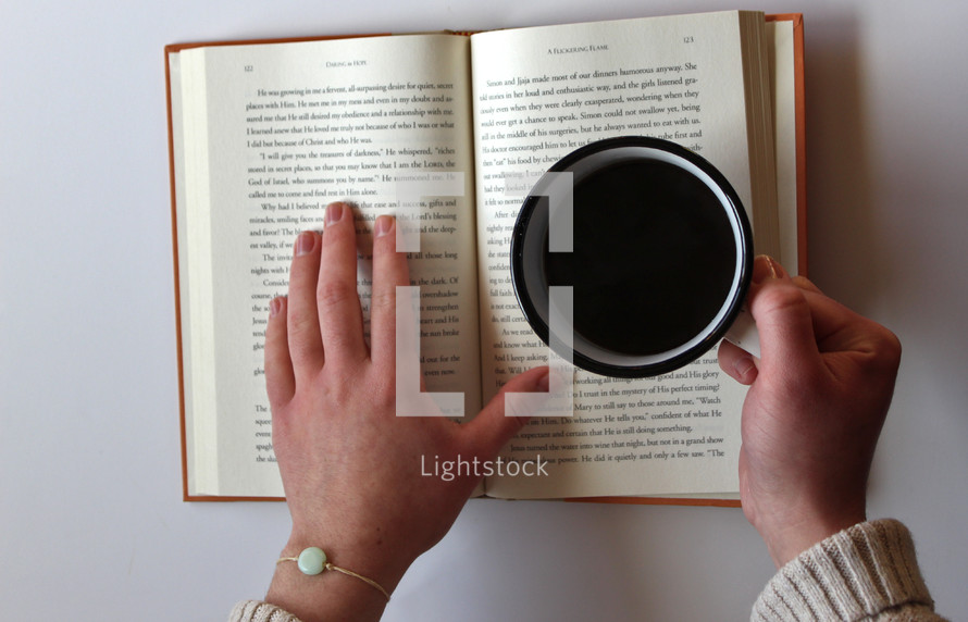 woman reading a book with a mug of coffee 