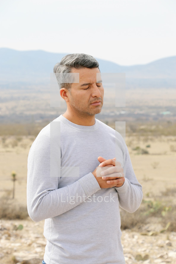 a man praying in a desert 