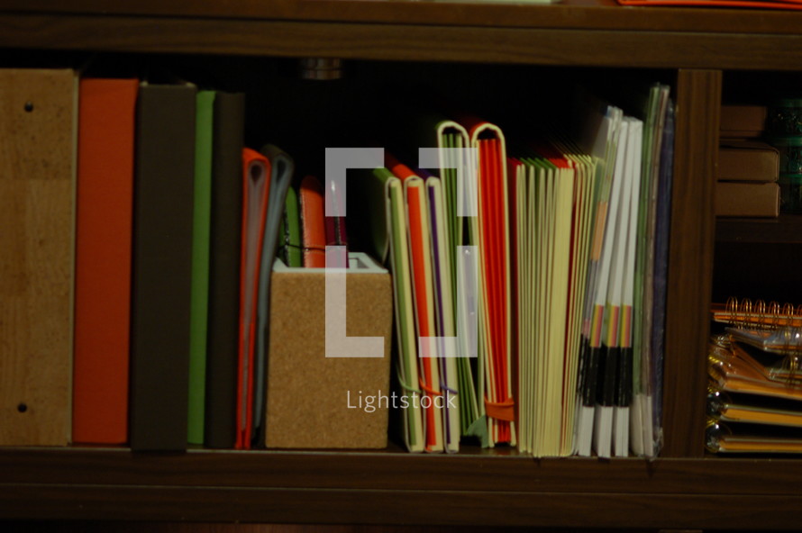 Bookshelf with books and binders.