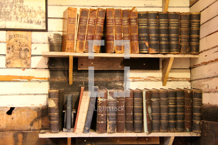 rows of antique books on bookshelves 