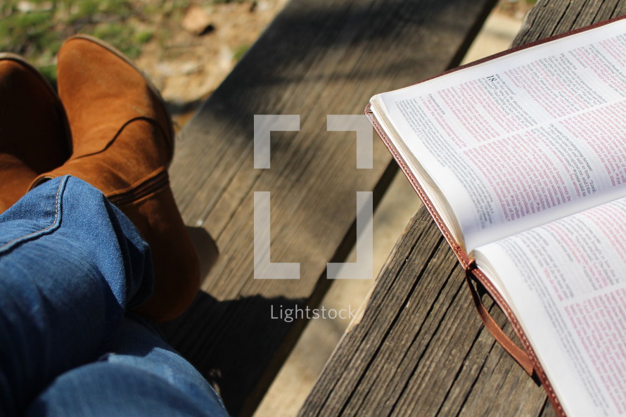 a woman's boots and an open Bible 