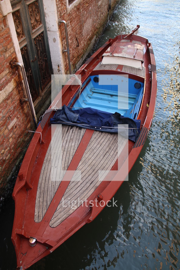 boat docked against a brick wall of a building