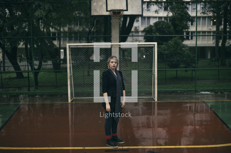 a woman standing on a wet basketball court 
