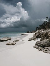 storm clouds over a white sand beach 