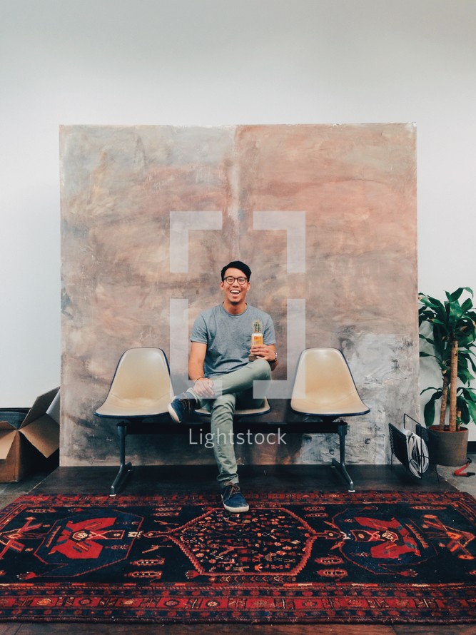 man sitting in a chair in a waiting room 