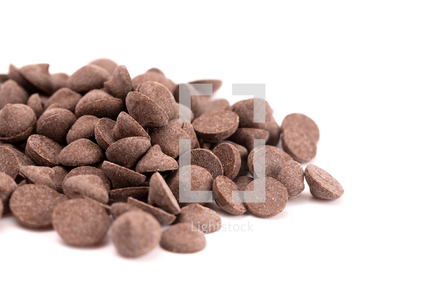 A Pile of Unsweetened Carob Chips on a White Background