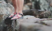 standing in sandals on a rocky ledge