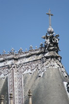 cross on an ornate rooftop