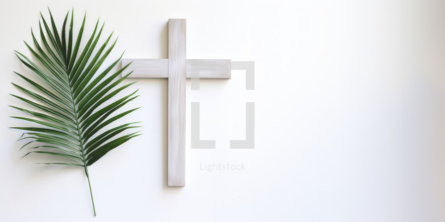 Palm Sunday. Cross and palm leaf on a white wall background with copy space.