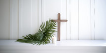 Palm Sunday. Cross, candle and palm leaf on a white shelf
