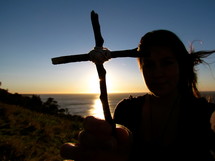 teen girl holding a cross made out of sticks 