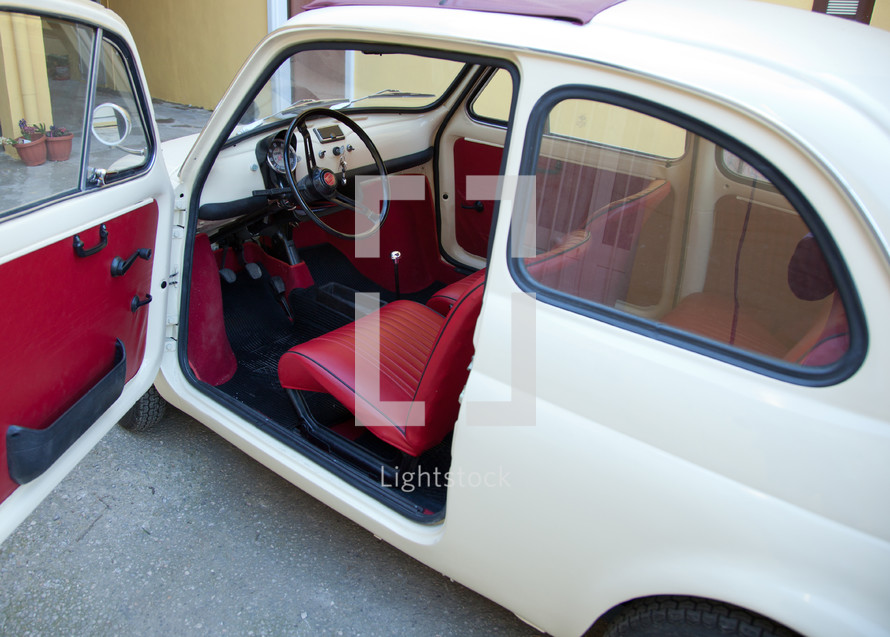 Florence, Italy - January 12, 2012: Fiat 500 was one of the most produced European cars. Side view with open door.