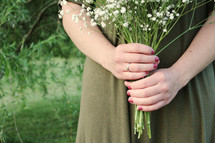 a woman holding a bouquet of picked flowers 