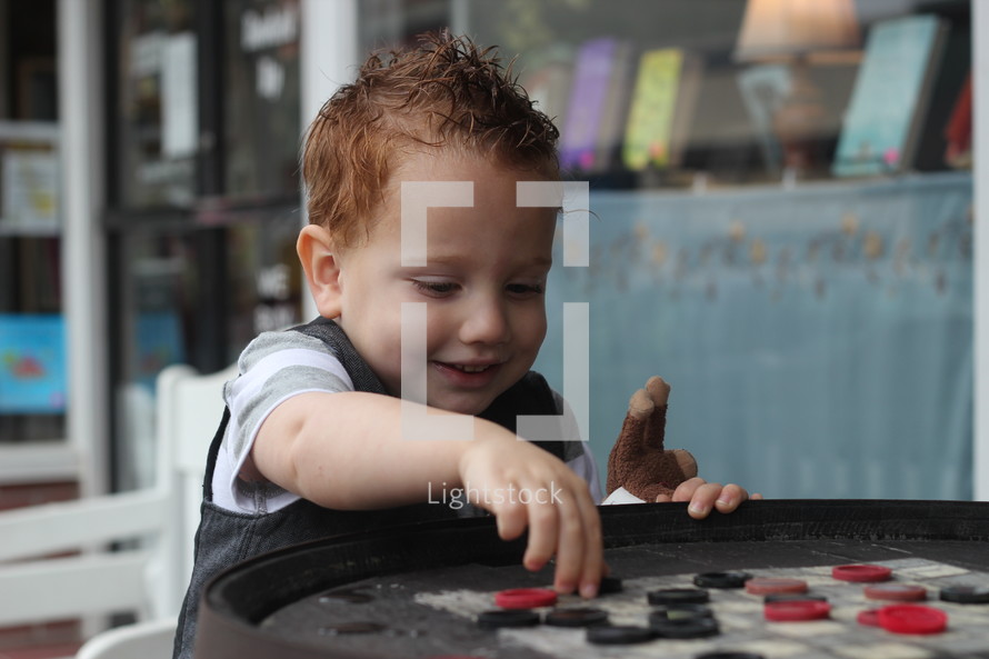 toddler boy playing checkers