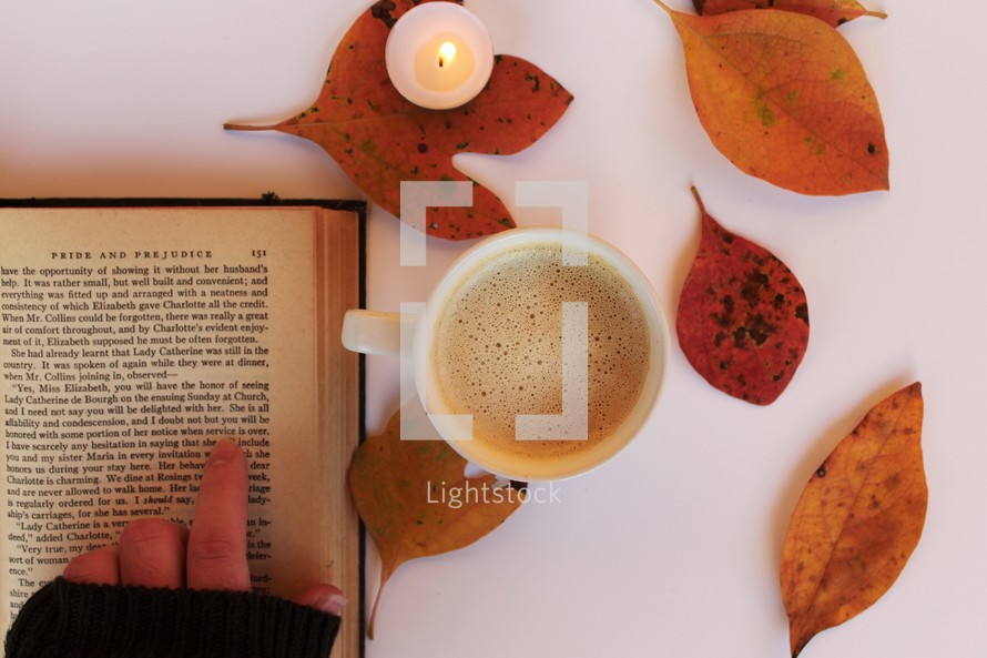 fall leaves around a latte and an open Book