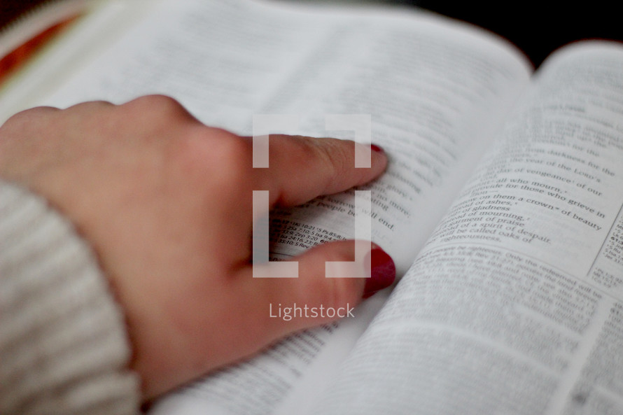 a woman's hand pointing to scripture 