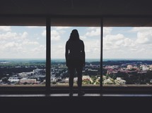 silhouette of a woman standing in a window 