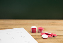 Simple Math Worksheet on a Wooden Table with counting markers 