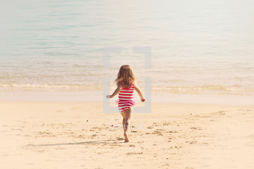 girl child running on a beach 