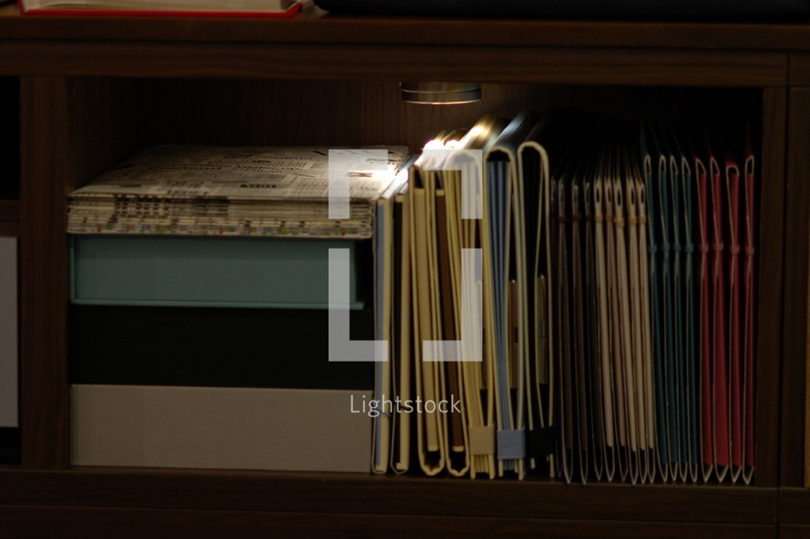 A shelf of books and binders.