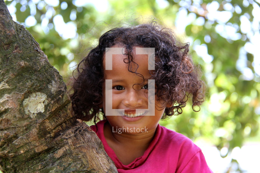 Young Polynesian girl with curly hair and huge smile