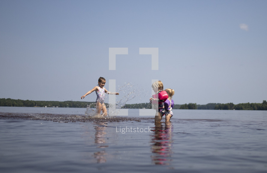 children playing in lake water 