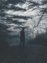 man standing in a foggy forest 
