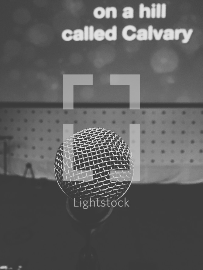 microphone and the words on a hill called Calvary on a projection screen 