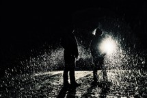 standing outdoors at night in rain 