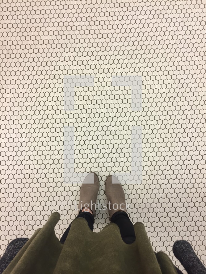 woman standing on honeycomb white tile floor 