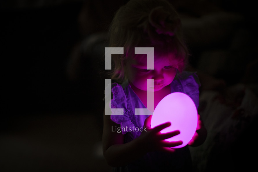 toddler girl holding a glowing orb 