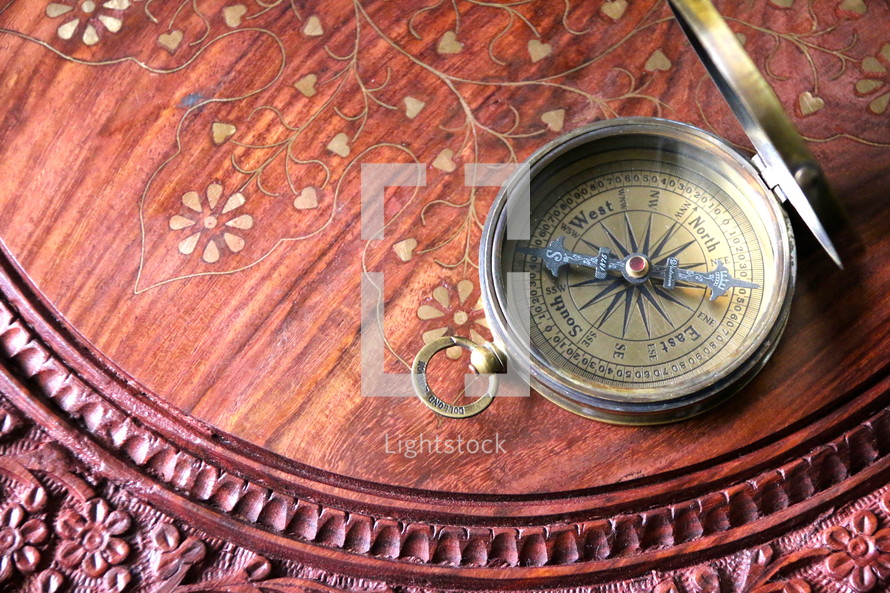 Brass magnetic compass on oriental wooden desk