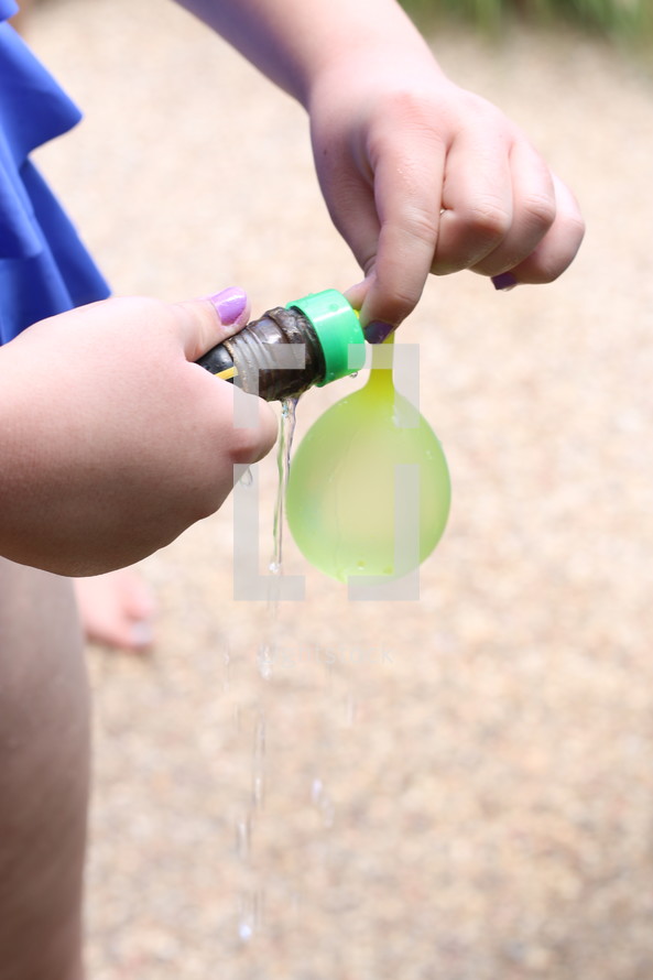 filling up water balloons with a hose 