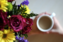 bouquet of flowers and a woman drinking coffee 