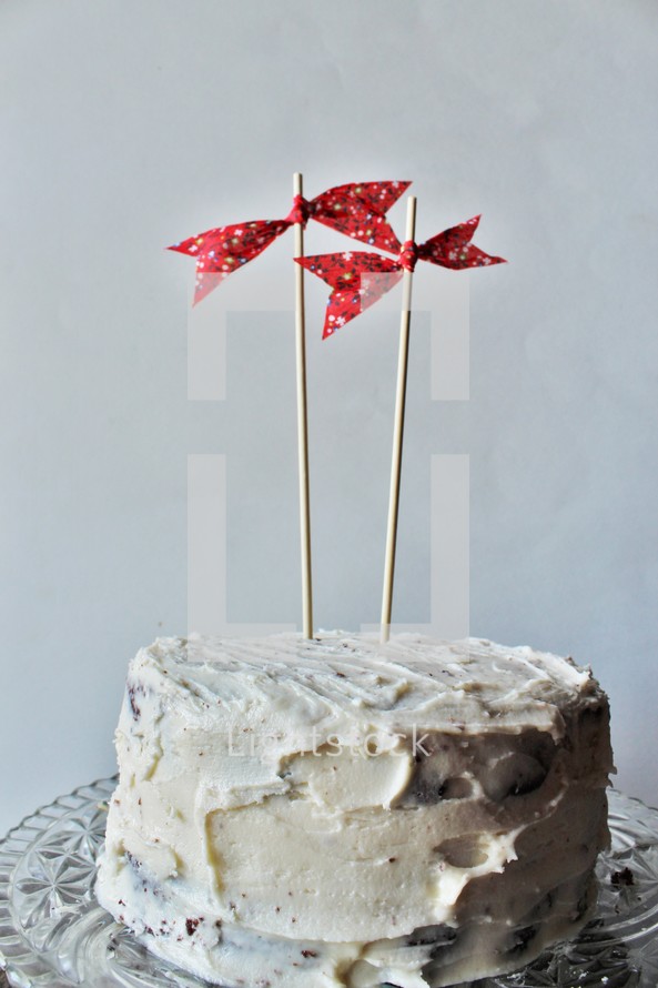 red bows on sticks on a cake 